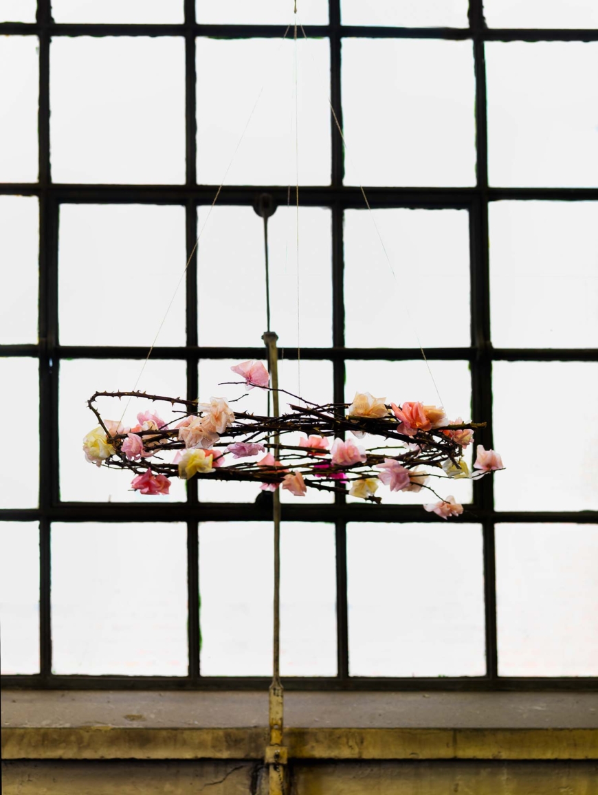 Takkrona gjord av nyponkvistar och pappersblommor.