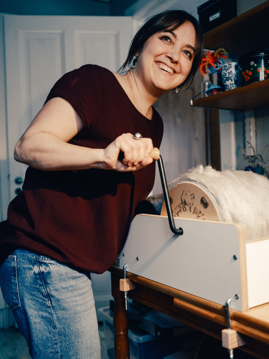 Liselotte Öhrling kardar ull med en kardmaskin.