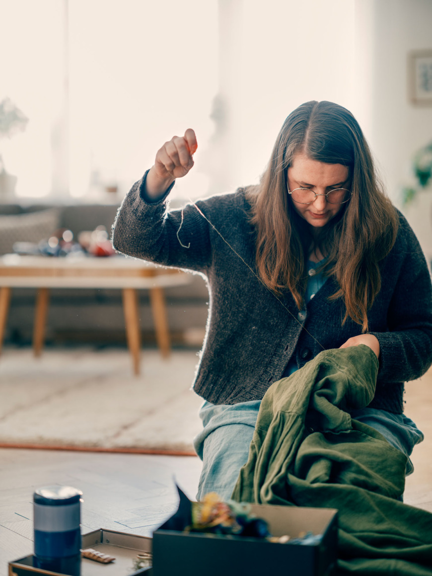 Emma Andersson sitter och syr.