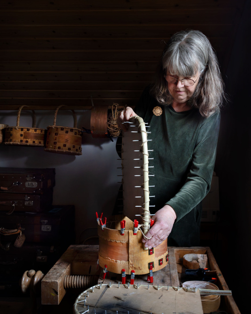 Siv Myhr med en näverkorg med långt handtag fastsatt på en mall.