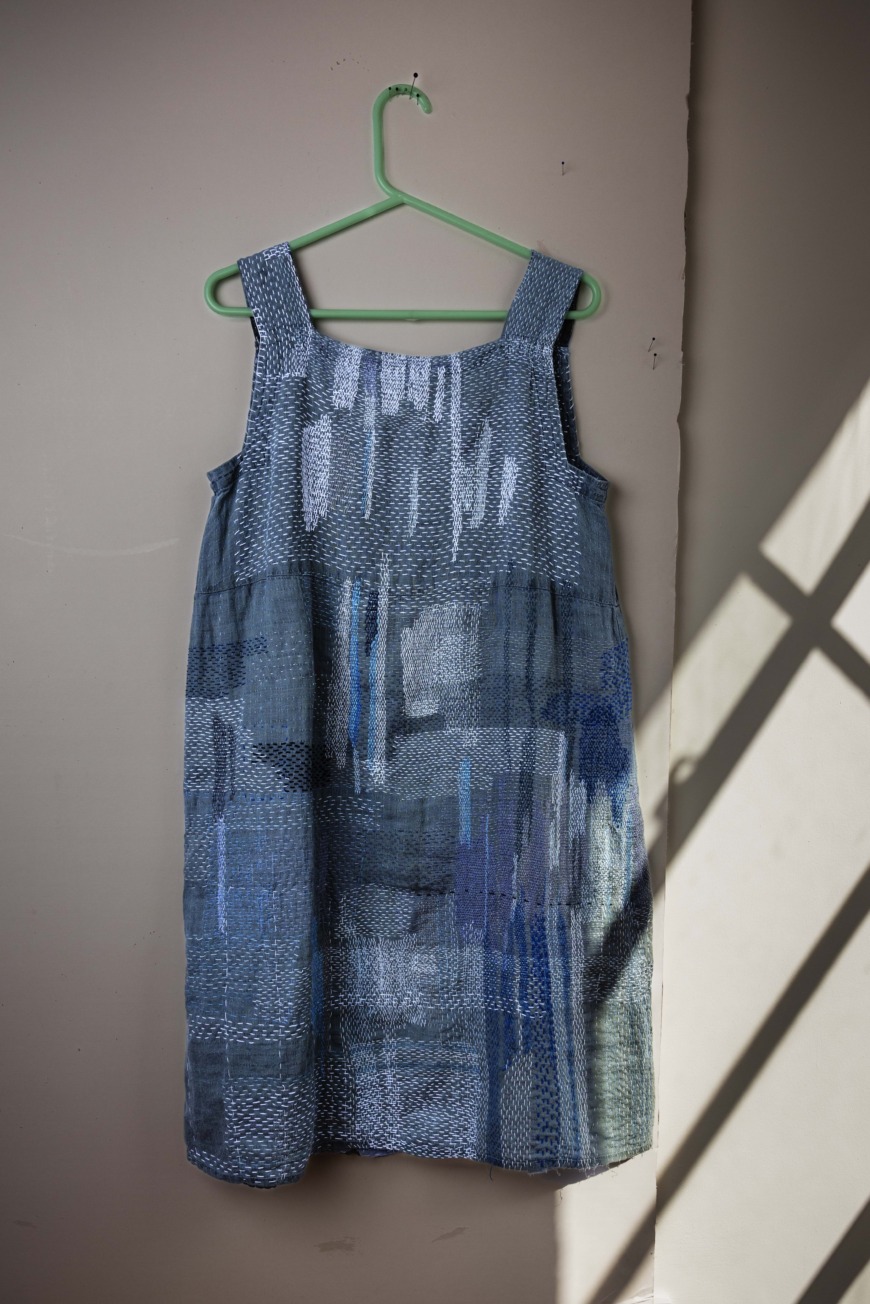 Blå ärmlösklänning med många lagningar.